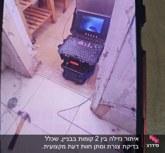 מחשב נייד עם מסך פתוח וכבל כחול על הרצפה